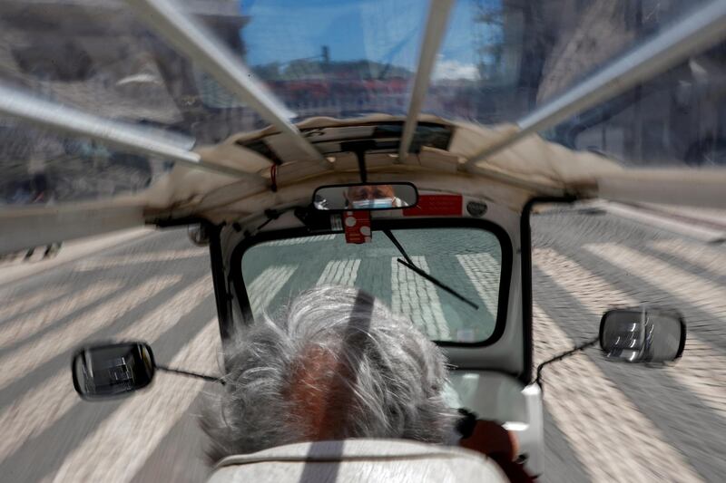 A man rides a tourist tuk-tuk along an empty street, amid the Covid-19 pandemic in Lisbon, Portugal. Reuters