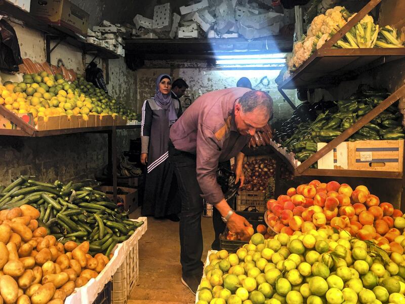 Sarah Al Hanbali, Jordan: Sarah captured this image of a fruits and vegetables merchant as he organises his shop in the local souq in Al-Salt city in Jordan.