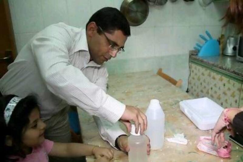 Muhammad Salah collects tap water samples from his home in Al Ain that will be tested for bacteria and safety.