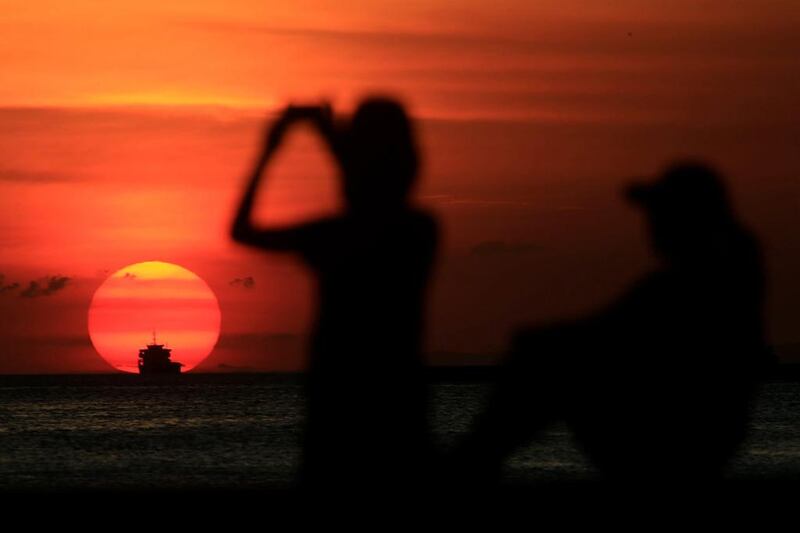 A group of friends are silhouetted as they take a photo while watching the sun set along the coast of Manila bay in Metro Manila, Philippines on January 27, 2017. Romeo Ranoco / Reuters