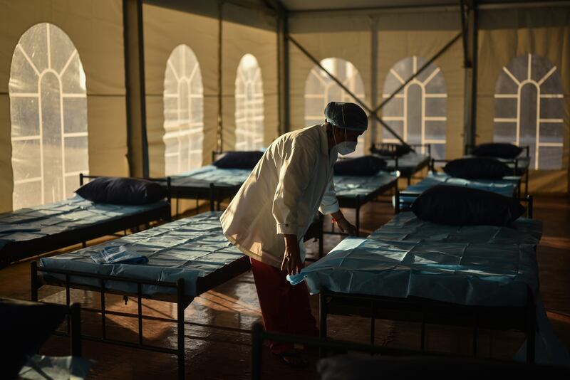 An Indian health worker prepares the medical beds at a makeshift COVID-19 care facility inside the Omandurar Government Medical College Hospital. EPA