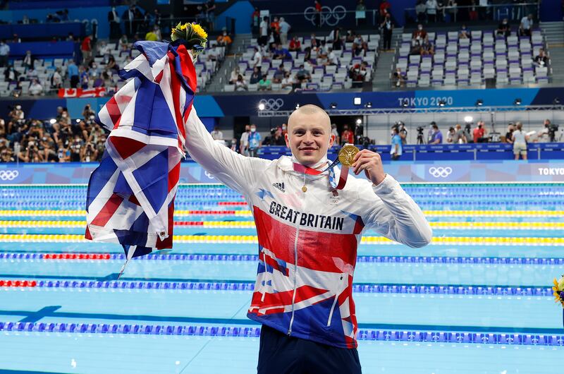 Adam Peaty of Great Britain celebrates with his gold medal.