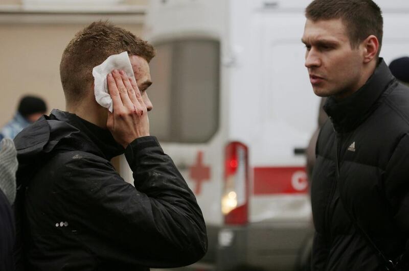 An injured person stands outside Sennaya Ploshchad metro station, following the explosion. Anton Vaganov / Reuters
