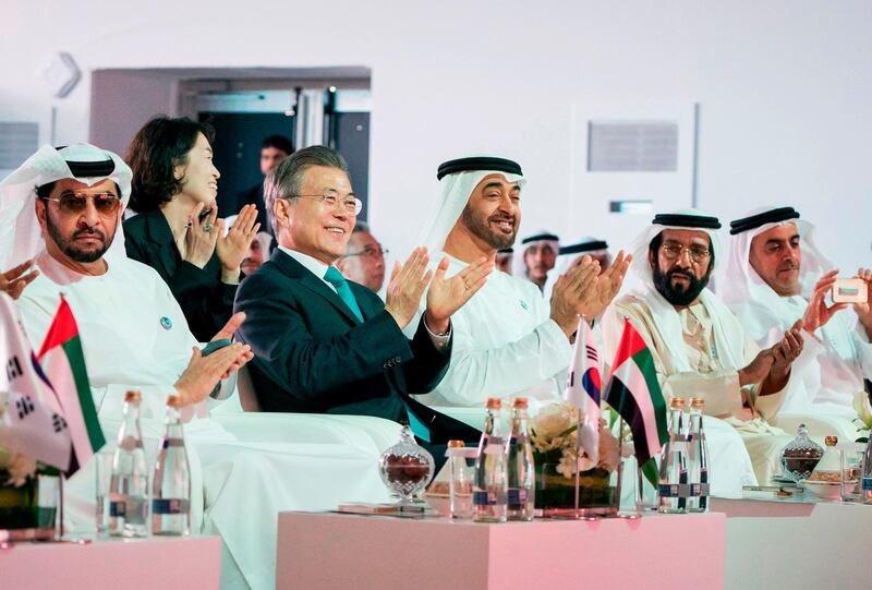 Sheikh Mohammed bin Zayed and South Korean President Moon Jae-in clap during a celebration ceremony for the completion of the first unit at the Barakah Nuclear Energy Plant on Monday.  WAM / Rashed Al-Mansoori