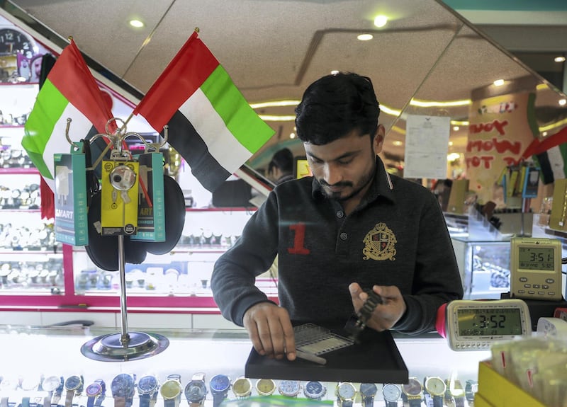 Abu Dhabi, U.A.E., November 26, 2018.  
Preparations for Emirates National Day. -- Mohammed Sakeer proudly displays the U.A.E. flag on top of his watch display.
Victor Besa / The National
Section:  SP
Reporter: Amith Passela