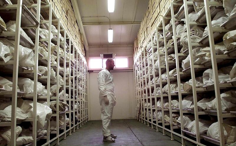 A Bosnian forensic expert of the Missing People Institute inspects bags containing the remains of up to 3,500 people believed to have been killed in the 1995 Srebrenica massacre, in Tuzla, Bosnia and Herzegovina, July, 10, 2001. EPA
