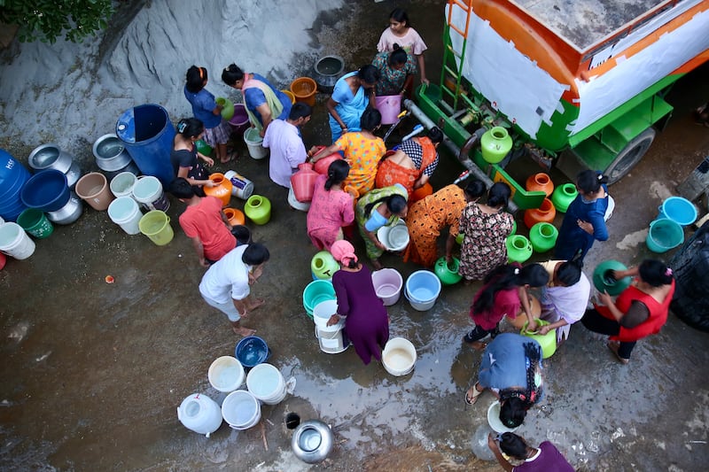 Residents collect clean drinking water from a free distribution water tanker in Rajarajeshwari Nagar, Bengaluru.  EPA