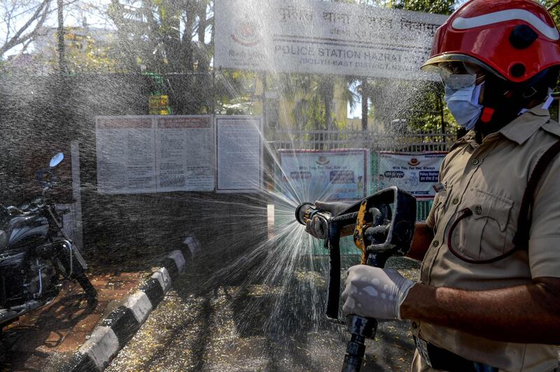 A firefighter disinfects a street near Nizamuddin Markaz Mosque, also known as Banglewali Masjid, during a government-imposed nationwide lockdown as a preventive measure against the COVID-19 coronavirus, in New Delhi on April 2, 2020.  / AFP / Sajjad HUSSAIN
