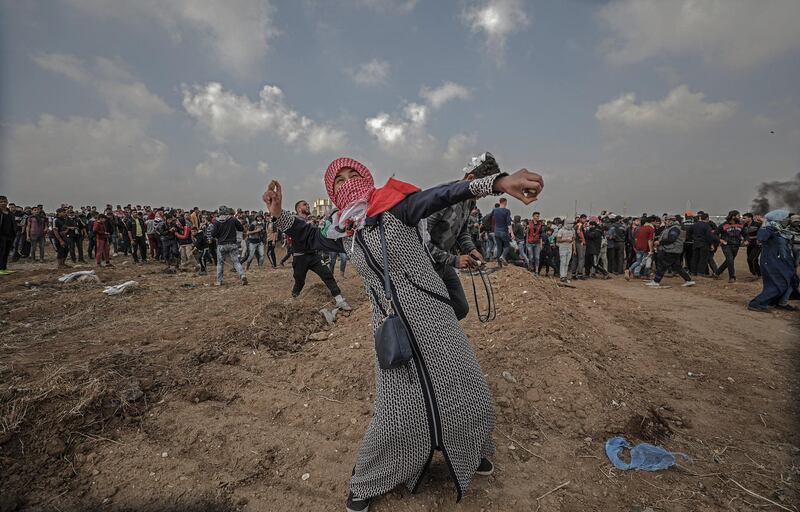 A female Palestinian protester throws stones during clashes after Friday protests near the border with Israel, in eastern Gaza City, Gaza Stip. Mohammed Saber / EPA