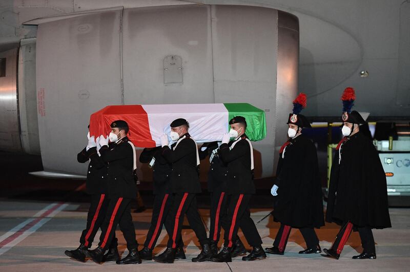 Carabinieri police officers carry one of the coffins. AFP
