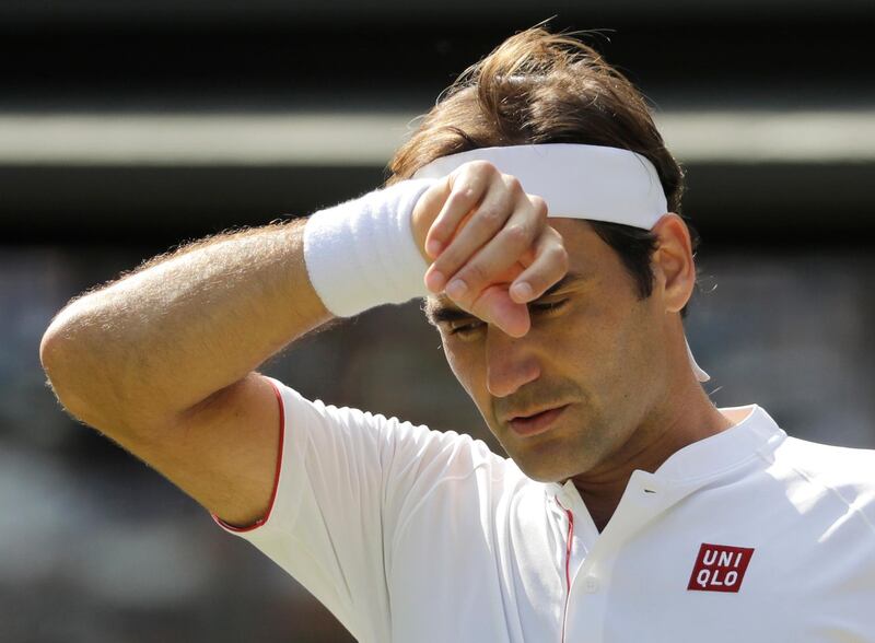 Switzerland's Roger Federer wipes his forehead during the fifth set of his men's quarterfinals match against Kevin Anderson of South Africa at the Wimbledon Tennis Championships, in London, Wednesday July 11, 2018. (AP Photo/Ben Curtis)