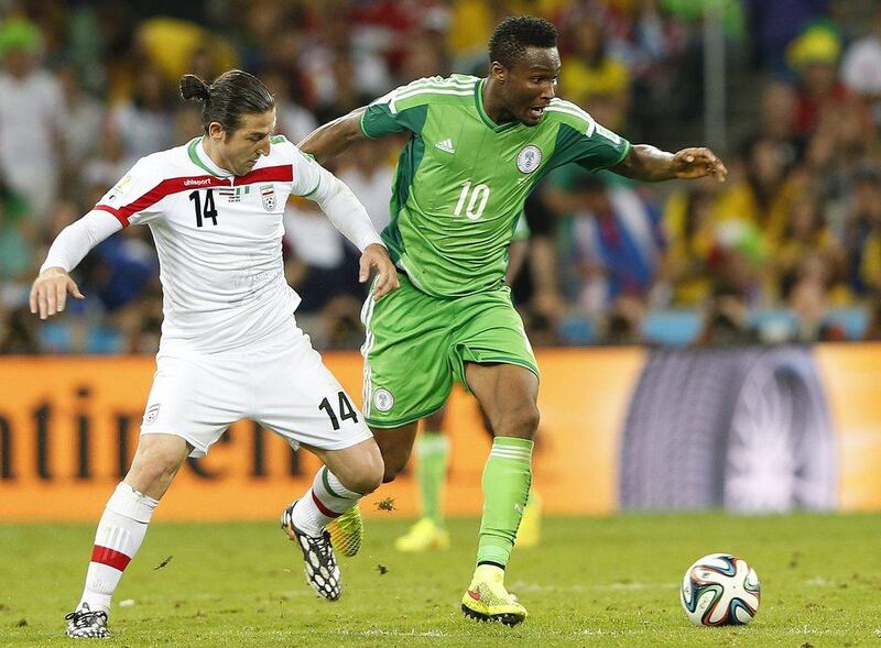 John Obi Mikel, right, and Andranik Timothian vie for the ball during Nigeria and Iran's draw at the 2014 World Cup on Monday. Rungroj Yongrit / EPA / June 16, 2014