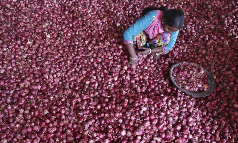 A labourer spreads onions for sorting at a wholesale vegetable market in the northern Indian city of Chandigarh. Heavy rains have damaged onion crops and delayed harvesting, putting further upwards pressure on prices. Ajay Verma / Reuters


