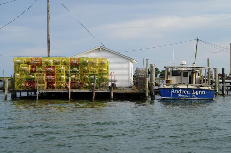 A crabbing boat is docked to next crab traps. 