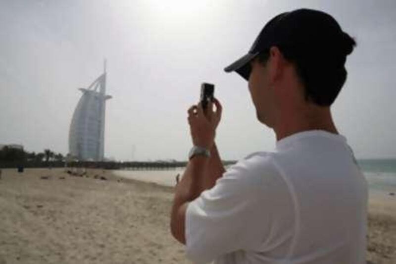 A tourist photographs the Burj Dubai; hoteliers say occupancy rates are down by a quarter.