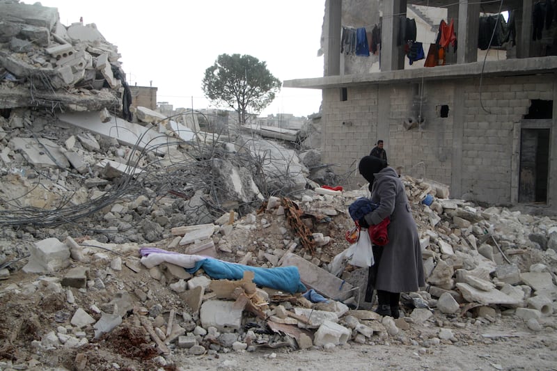 A survivor in the town of Jindayris, Aleppo province, tries to salvage items from the ruins after February's earthquake in Syria. Groups that supply humanitarian assistance to the quake zones say they are struggling despite western countries easing sanctions imposed upon Syria during the 12-year civil war. AFP