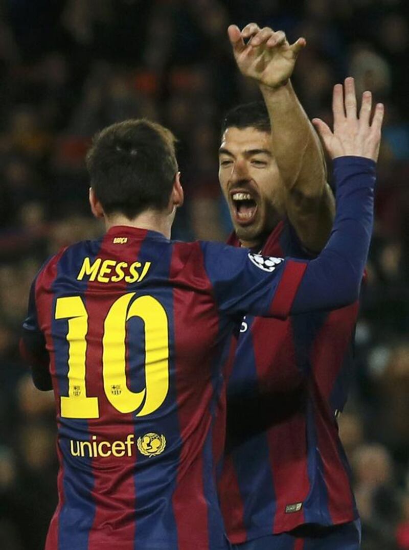 Barcelona's Lionel Messi, left, celebrates with teammate Luis Suarez after scoring a goal against Paris Saint-Germain during their Uefa Champions League Group F match at the Nou Camp stadium in Barcelona on December 10, 2014. Albert Gea / Reuters