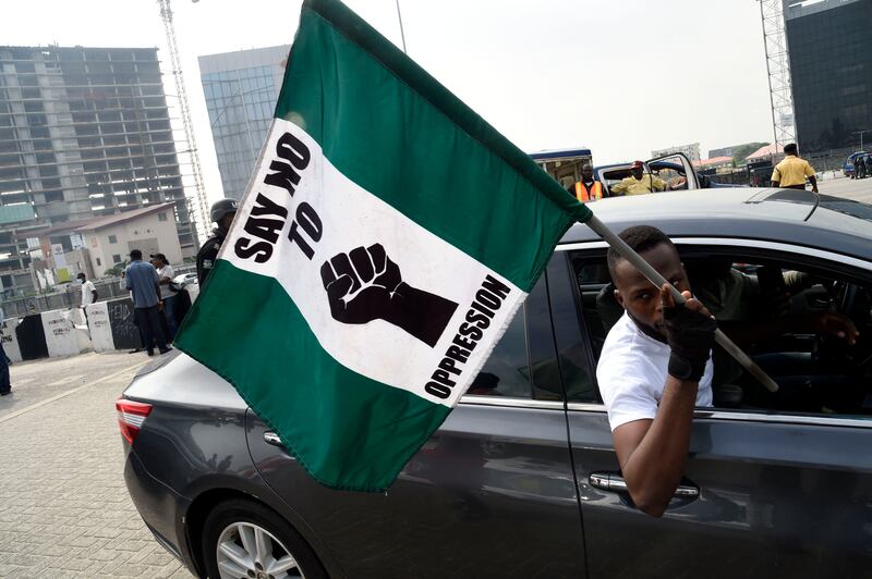 A man carries a national flag bearing the words: 'Say No To Oppression'.  AFP