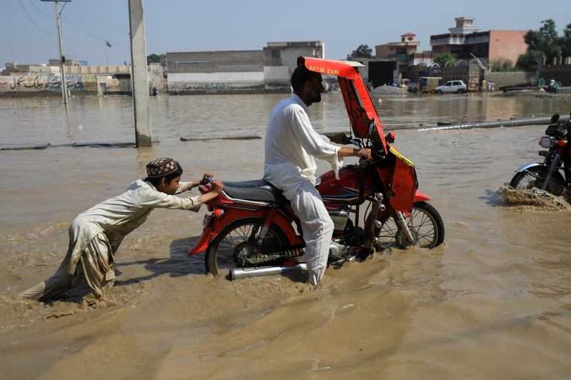 A boy pushes a motorbike after it stalled in Nowshera, Khyber Pakhtunkhwa province. Reuters