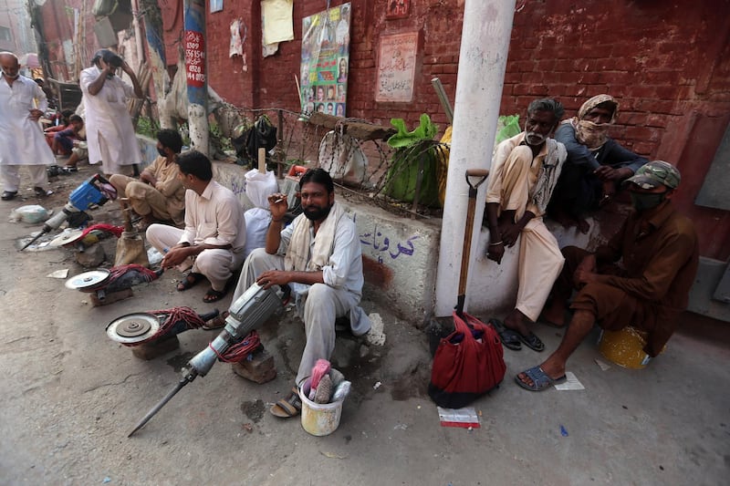 Laborers wait on a road during a lockdown in Lahore, Pakistan. EPA
