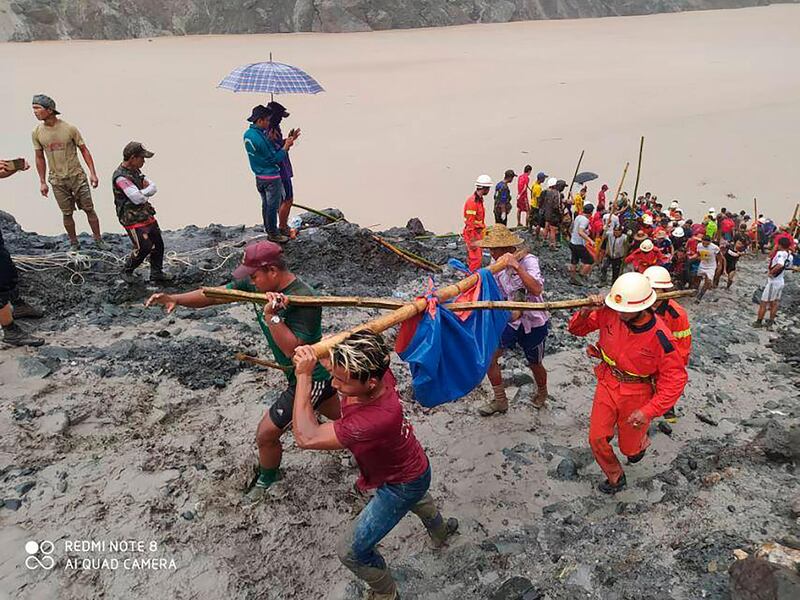 Myanmar Fire Service Department rescuers carry a recovered body of a victim in a landslide from a jade mining area in Hpakant, Kachine state, northern Myanmar. Myanmar Fire Service Department via AP