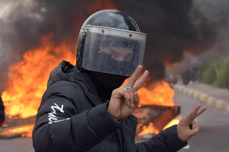 A demonstrator wearing a helmet poses for a photograph during ongoing anti-government protests in Nassiriya, Iraq. Reuters