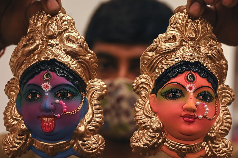 A shopkeeper displays idols representing deities and characters from Hindu mythology in Chennai. AFP