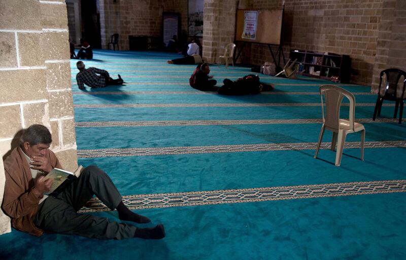 A Palestinian man reads verses of the Quran at Al Omari mosque in Gaza City. AP Photo