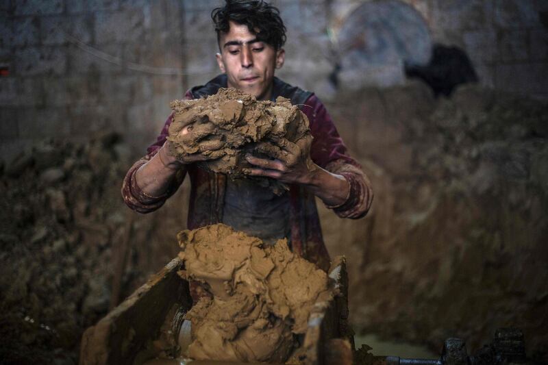 A son of Palestinian potter Sid Atallah prepares clay at the family workshop in Deir al-Balah in the central Gaza Strip. AFP