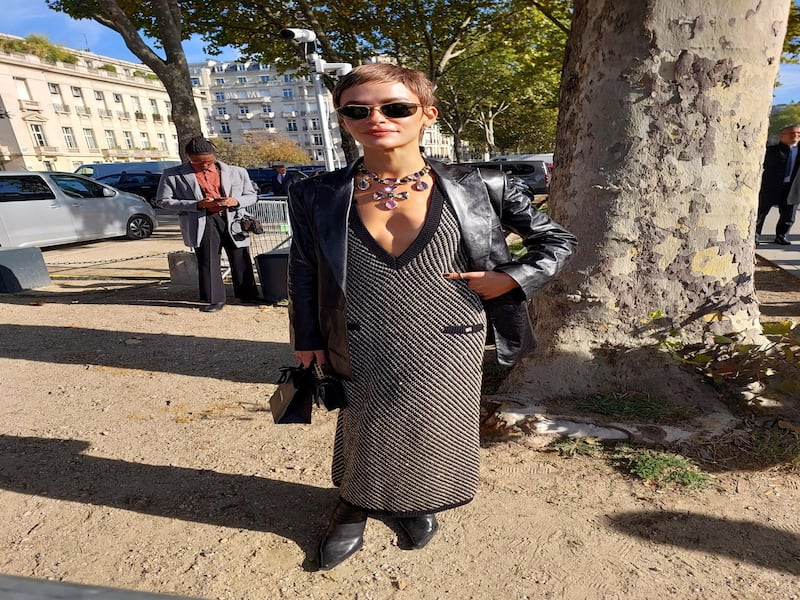 Wearing a gold knitted dress and a pixie cut. Spotted outside Chanel.
