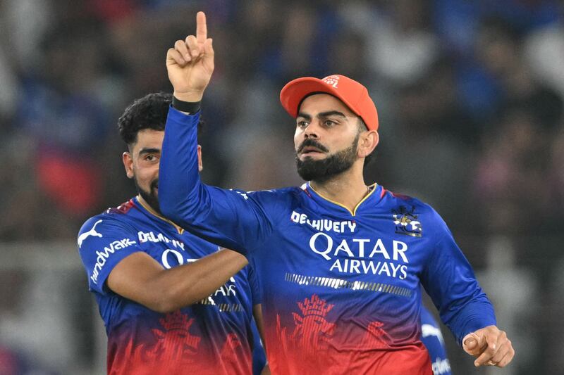 Royal Challengers Bengaluru's Virat Kohli (R) celebrates after taking the wicket of Rajasthan Royals' Dhruv Jurel during the Indian Premier League (IPL) Twenty20 eliminator cricket match between Royal Challengers Bengaluru and Rajasthan Royals at the Narendra Modi Stadium in Ahmedabad on May 22, 2024.  (Photo by Punit PARANJPE  /  AFP)  /  -- IMAGE RESTRICTED TO EDITORIAL USE - STRICTLY NO COMMERCIAL USE --