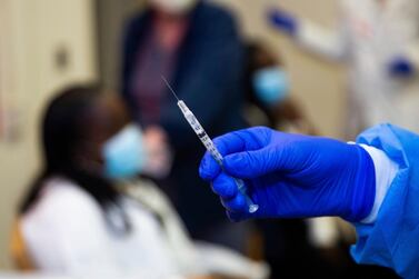 A doctor prepares to administer a vaccine injection. AP
