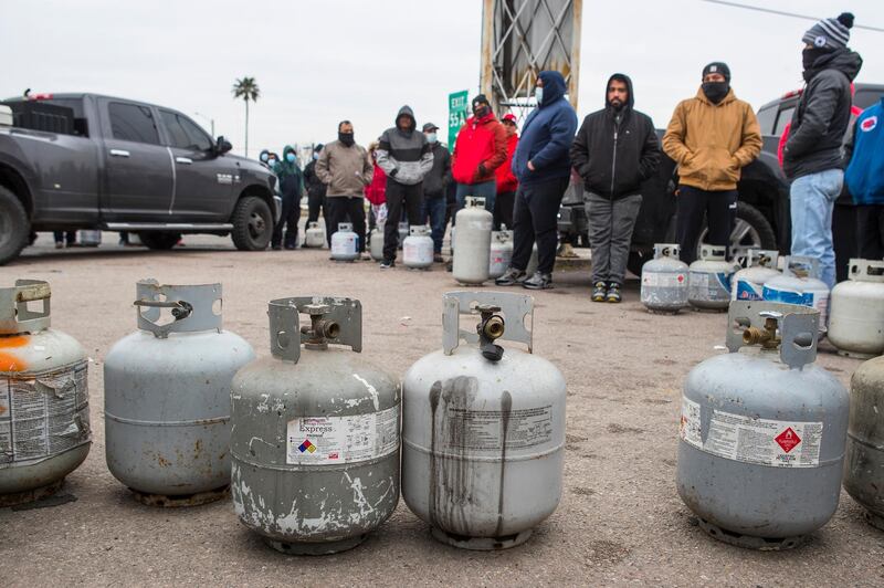 People queue to fill their empty propane tanks in Houston. The temperature stayed below freezing on Tuesday. AP