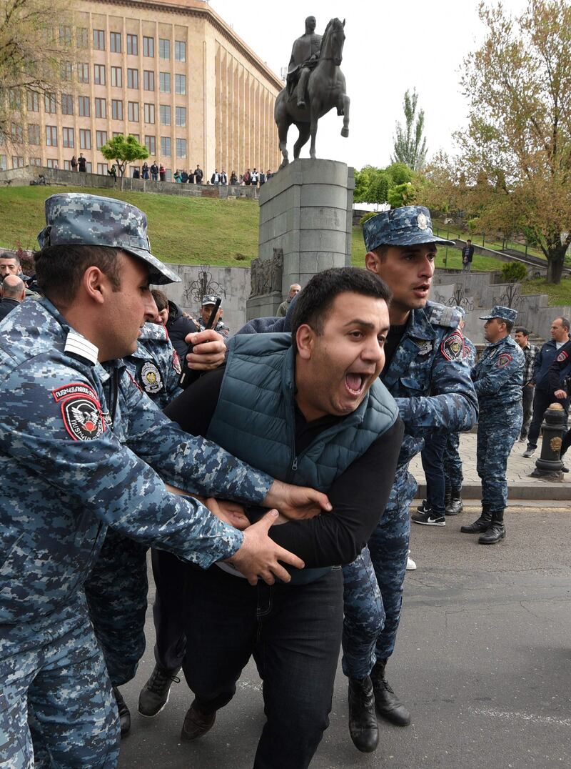 Armenian police officers detain a demonstrator. AFP