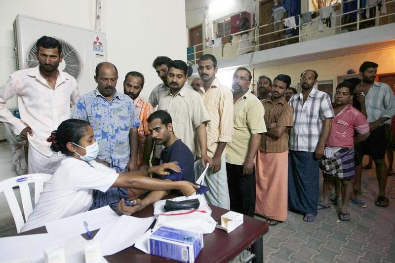 Indian workers get their blood pressure checked at a free clinic set up at a Mussafah labour camp. Stephen  Lock / The National 