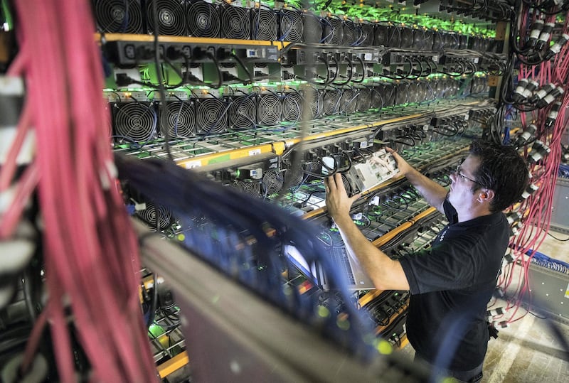 A technician removes a cryptocurrency mining rig from a rack at a Bitfarms facility in Saint-Hyacinthe, Quebec, Canada, on Thursday, July 26, 2018. Bitcoin has rallied more than 30 percent in July, shrugging off security and regulatory concerns that have plagued the virtual currency for much of this year. Photographer: James MacDonald/Bloomberg