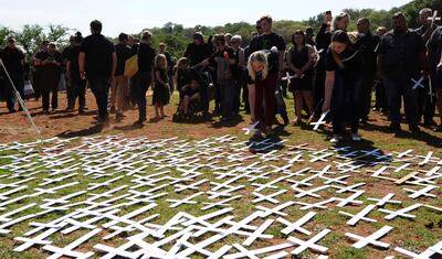 In this photo taken Oct. 30, 2017 people place white crosses, representing farmers killed in the country, at a ceremony at the Vorrtrekker Monument in Pretoria, South Africa.  U.S. President Donald Trump has tweeted that he has asked the Secretary of State Mike Pompeo to "closely study the South African land and farm seizures and expropriations and the large scale killing of farmers." Trump added, "South African Government is now seizing land from white farmers." (AP Photo)