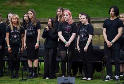 Members of the Manchester Survivors' Choir and Parrs Wood High School Choir sing during the opening of the Glade of Light Memorial, outside Manchester Cathedral, to commemorate the victims of a suicide bomb attack at a 2017 concert. AP