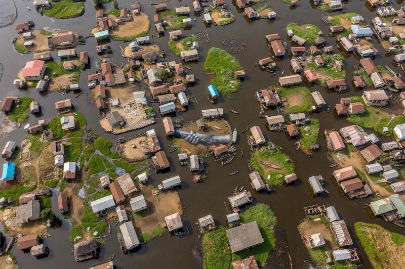 An aerial view of one of the artworks by artist Guillaume Legros, also known as Saype, from his global project, 'Beyond Walls', in Ganvie, Benin. The project started in front of the Eiffel Tower in Paris and travelled around the world for years before reaching Benin's floating village of Ganvie. AFP