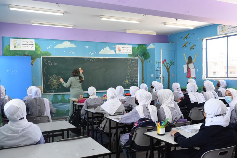 Pupils have now returned after reconstruction work and here a teacher gives a lesson to a packed classroom. Rosie Scammell / The National