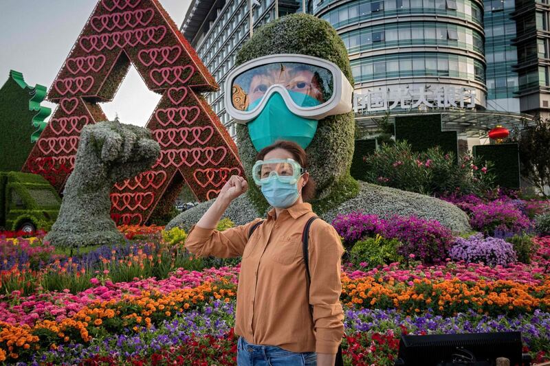 A woman poses for a photo in front of a flower display dedicated to frontline healthcare workers during the Covid-19 pandemic in celebration for the upcoming National Day of the People's Republic of China, in Beijing. AFP