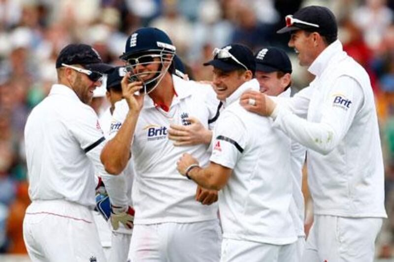 England's Alastair Cook, second left, celebrates with his teammates after pulling off a spectacular catch to dismiss Ishant Sharma.