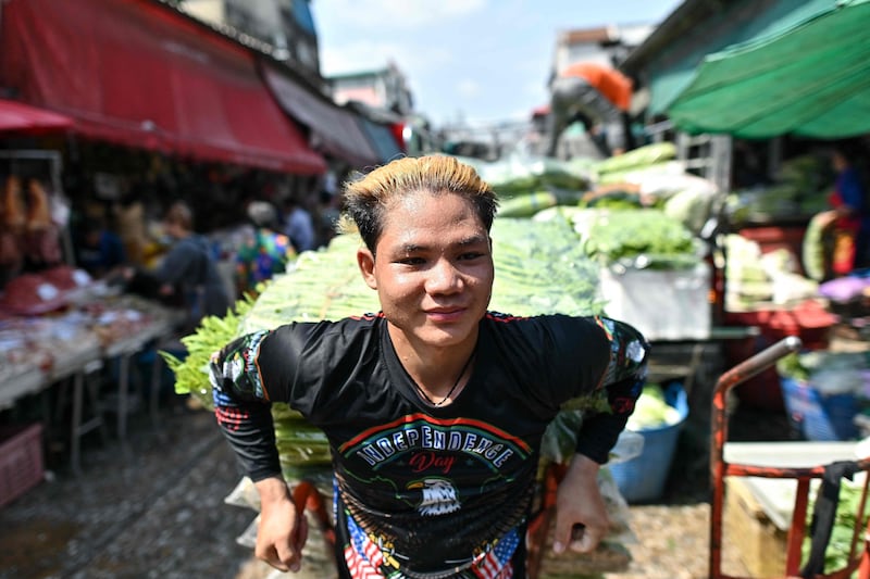 A vendor sweats as he pulls a vegetable cart at Khlong Toei, the biggest fresh produce market in Bangkok. AFP