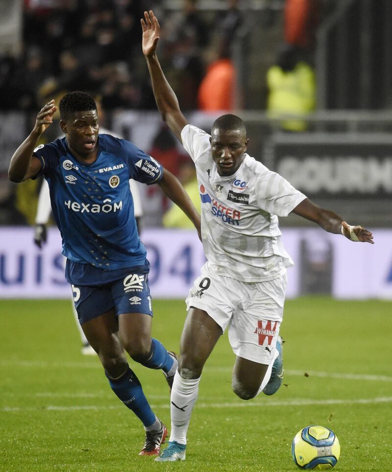 Reims' Zimbabwean midfielder Marshall Munetsi (L) vies for the ball with Amiens' French forward Sehrou Guirassy during the French L1 football match between Amiens and Reims on January 15, 2020 at the Licorne Stadium in Amiens. (Photo by FRANCOIS LO PRESTI / AFP)