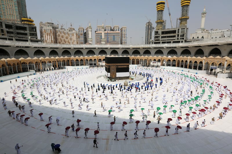 Pilgrims hold coloured umbrellas along matching coloured rings separating them, part of a Covid-19 safety measure, as they circle the Kaaba in July 2020. AFP