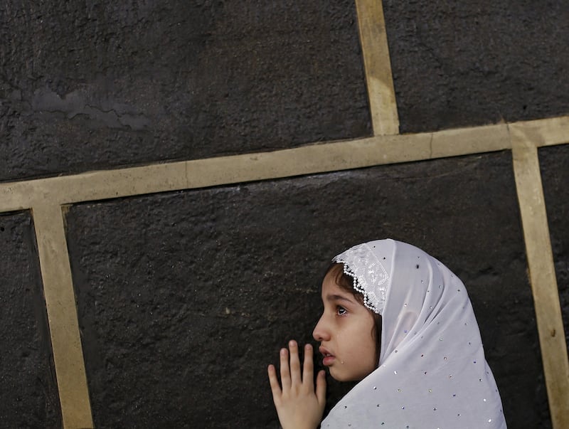 A Muslim girl touches the Kaaba at the Grand Mosque in Makkah in September 2015. Reuters