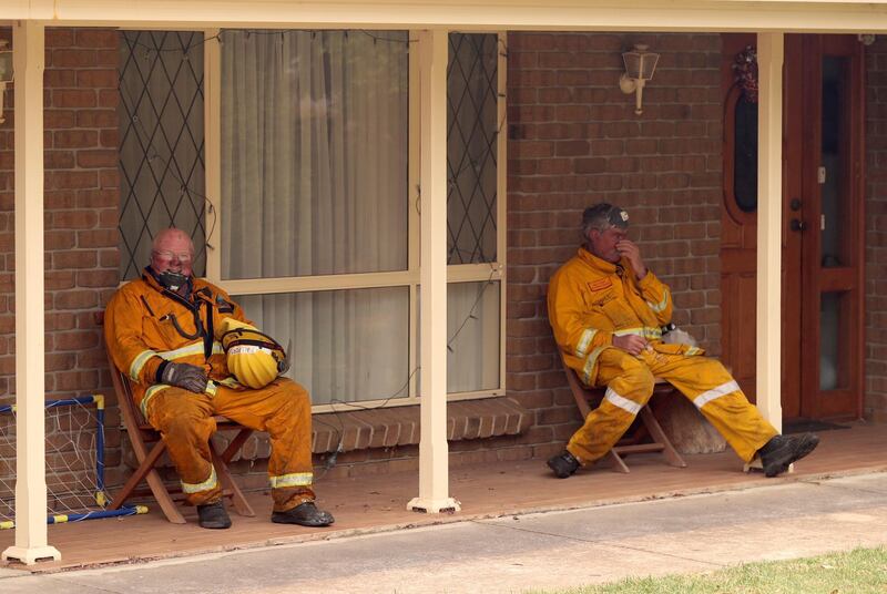 Firefighters rest at a house on Jacaranda Drive at Woodside in the Adelaide Hills in Adelaide.  EPA