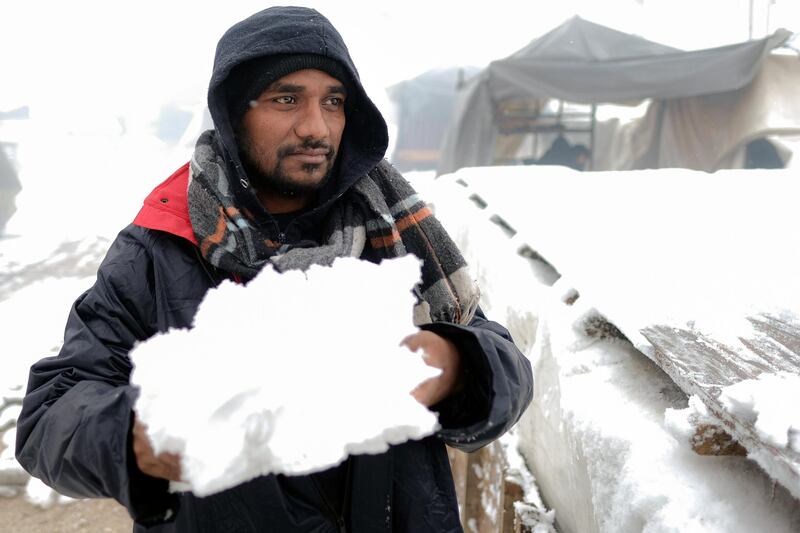 A migrant carries snow at the Lipa camp. AP Photo