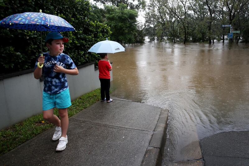 Young local children look out at rising floodwaters along the Hawkesbury River from the CBD of Windsor. Getty Images