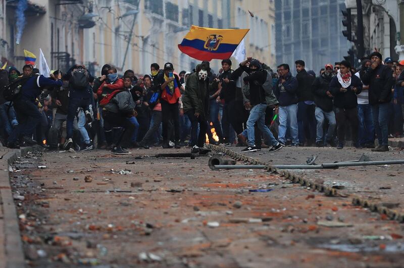 epa07894063 Demonstrators clash with police officers during a protest against the economic measures adopted by the Ecuadorian Government led by President Lenin Moreno, in Quito, Ecuador, 03 October 2019. Moreno announced the elimination of gasoline subsidies, labor reforms, tax changes and other economic measures in order to meet conditions imposed by the International Monetary Fund (IMF).  EPA/Jose Jacome